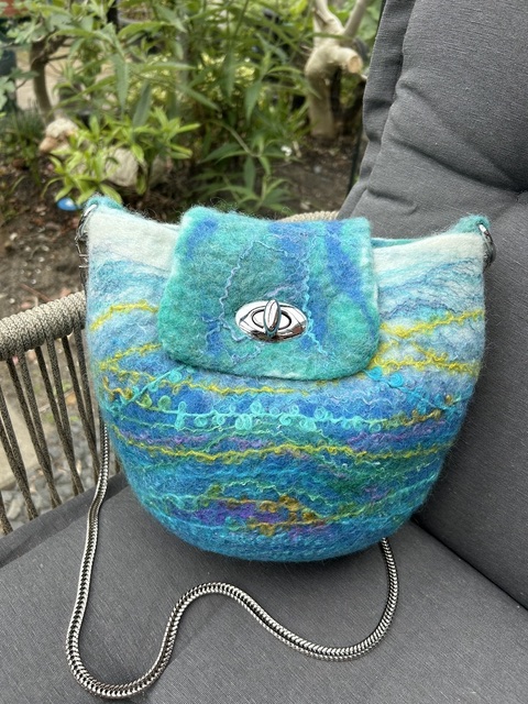 Gevilte tas in blauw- en groentinten met zilveren sluiting en ketting
